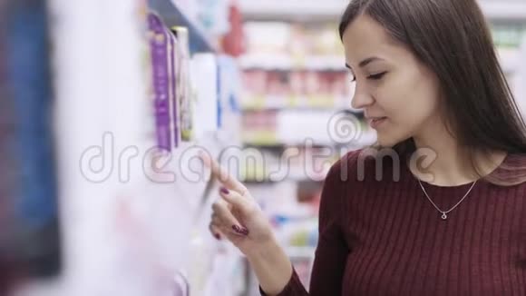 美女肖像正在超市里寻找价格标签和产品视频的预览图
