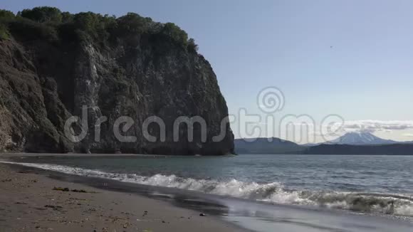 海面上平静的海浪来自黑色火山沙的海滩太平洋岩石海岸视频的预览图