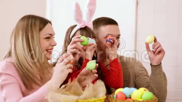 一家人突然用一个明亮漂亮的复活节彩蛋用刷子把手拉起来视频的预览图