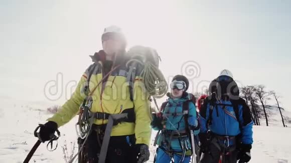 登山队的资深队员用冰镐向小路手显示方向队伍听他的视频的预览图