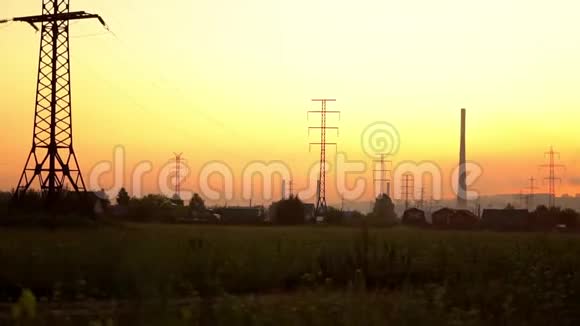 房屋附近日落时的高压电塔视频的预览图