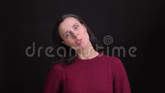 成年白种人女性在看镜头时扮演一个傻瓜并做出滑稽的面部表情视频的预览图