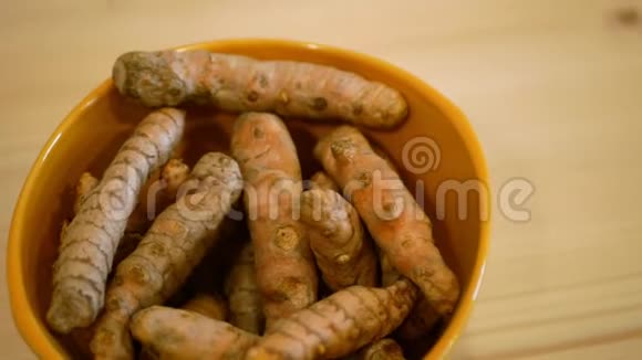 姜黄根的根茎姜黄在碗里把印度藏红花煮熟后磨成黄色粉末所用视频的预览图