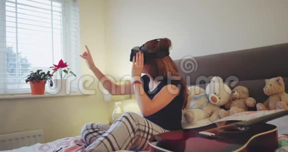 在一个现代的卧室里年轻的青少年玩虚拟现实眼镜她对一项新发明印象深刻视频的预览图