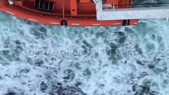 橙色的小船经过蓝色寒冷美丽的水俯视视频的预览图