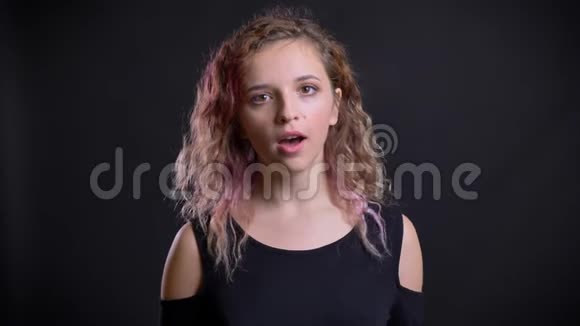 年轻的白种人女孩的肖像粉红色的头发观看镜头与娱乐在黑色背景视频的预览图
