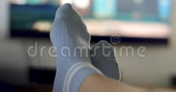 穿着蓝袜子看电视的人双腿交叉视频的预览图