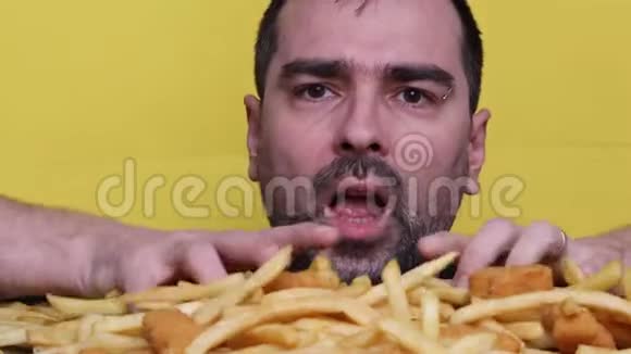 吃垃圾食品营养和饮食健康问题的概念年轻人用两只手吃大量不健康的快餐视频的预览图