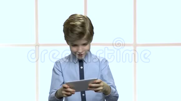 专心致志的小男孩玩手机游戏视频的预览图