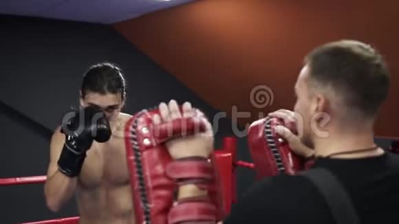 用拳击手套与教练一起进行有动力的跆拳道训练准备比赛脸上出汗视频的预览图