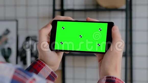 男子手持黑色智能手机与空白绿色屏幕色度关键概念视频的预览图