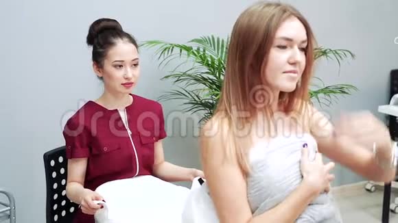 年轻的亚洲女性美容师为一个女孩准备美容手术视频的预览图