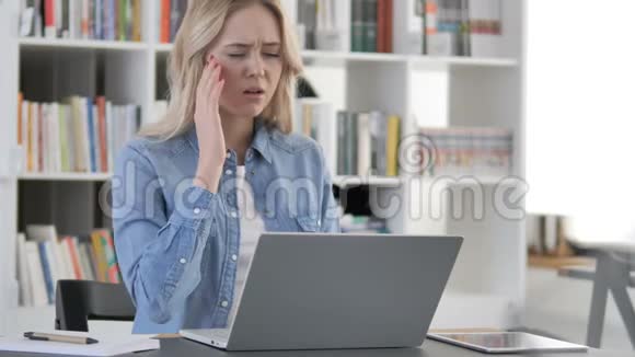 戴头巾的年轻女士在笔记本电脑上工作视频的预览图