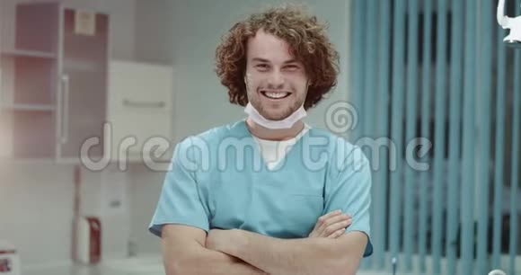 年轻人带着卷发和完美牙齿的微笑快乐医生的画像邀请你去他的诊所视频的预览图