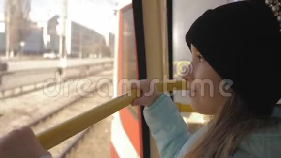 小女孩在地铁里看着车的窗户视频的预览图
