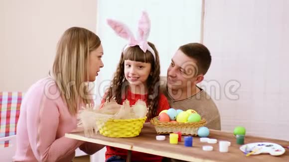 幸福的家庭由妈妈爸爸和女儿组成默默地商量着然后突然带着微笑向镜头展示视频的预览图