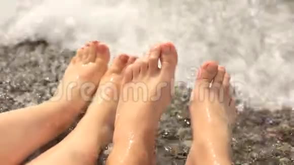 女人和男人脚在鹅卵石海滩上的海里休息和旅行度假视频的预览图