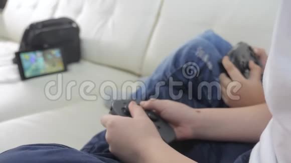 孩子们在游戏游戏中玩游戏机孩子们一个男孩和一个女孩正在生活方式电视中玩一个便携式机顶盒视频的预览图