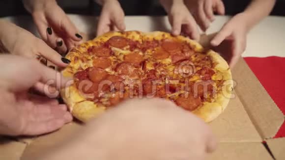 人手从打开的盒子里拿几片美味的意大利热比萨饼在聚会上提供送餐服务视频的预览图