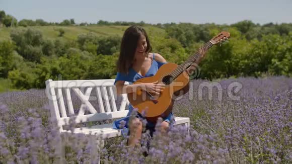 积极微笑的女人在大自然中弹吉他视频的预览图