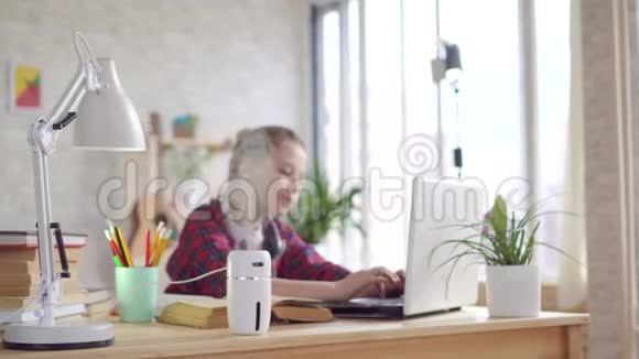 桌上的加湿器和一个使用笔记本电脑的青少年视频的预览图