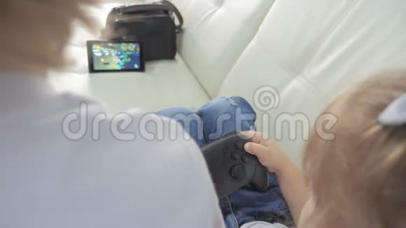 孩子们在游戏游戏中玩游戏机一个男孩和一个女孩正在电视控制器里玩一个便携式机顶盒视频的预览图