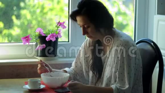 穿着睡衣的年轻女士早餐吃燕麦片和草莓视频的预览图