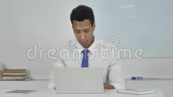 愤怒的非裔美国商人愤怒和沮丧地在笔记本电脑上工作视频的预览图