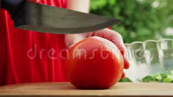 女人手拿大红番茄开始切视频的预览图