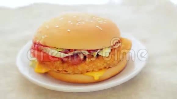 汉堡和鸡切片番茄和奶酪在一个白色的盘子上旋转成一个圆圈视频的预览图