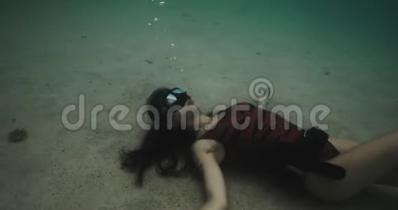 潜水妇女躺在水下海底拍摄于电影摄影机12位彩色视频的预览图
