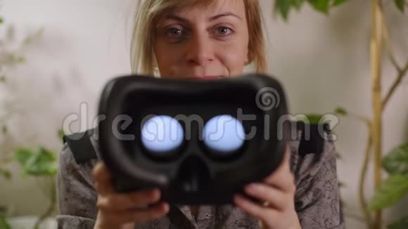 年轻女子把虚拟现实的护目镜放进照相机视频的预览图