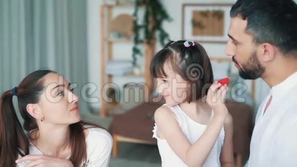 快乐的家庭在厨房妈妈爸爸和女儿吃草莓慢动作视频的预览图