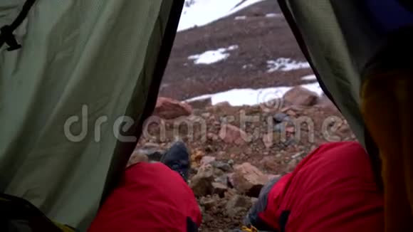 从雪山上的帐篷中观看太阳光正落在岩石上视频的预览图