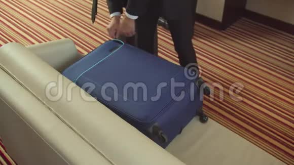 男人打开手提箱把衣服放在沙发上视频的预览图
