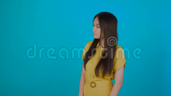 微笑自信的年轻女子长发手指相机与蓝色背景隔离视频的预览图