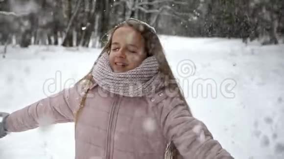 冬日森林的乐趣女孩在飘落的白霜下旋转视频的预览图