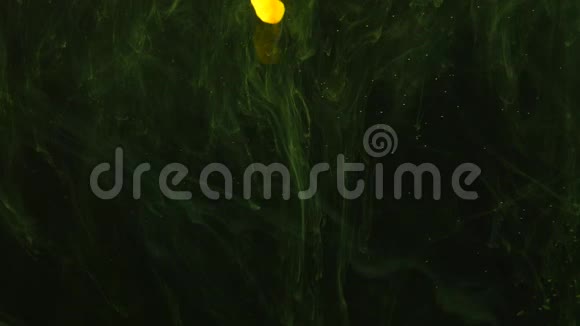 黄色透明的烟雾花出现在黑暗的背景上小点和周围的绿色薄雾视频的预览图