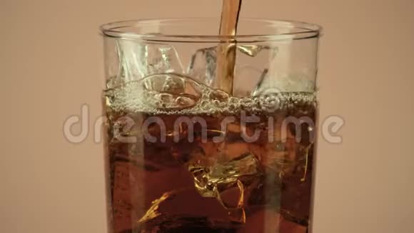 将棕色饮料倒入杯中在棕色背景下加入冰块特写慢动作拍摄红色视频的预览图