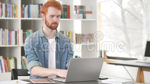 忙碌的红发人在笔记本电脑上工作视频的预览图