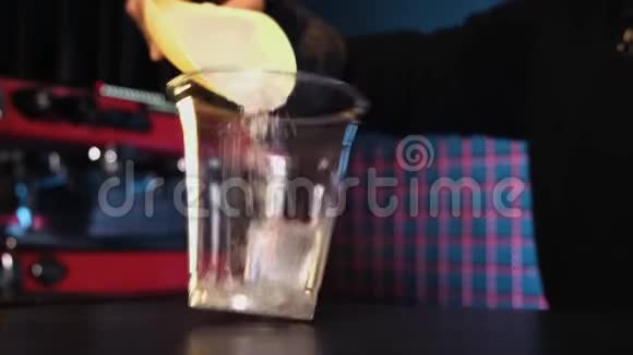 酒保把冰块扔进一个塑料杯里冷饮制作工艺视频的预览图