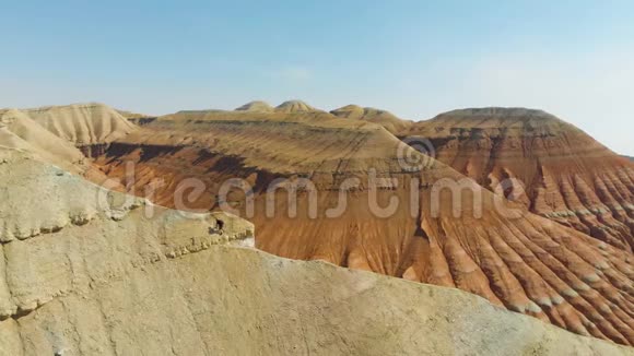 一个背着旅行背包的人沿着山脊向上走视频的预览图