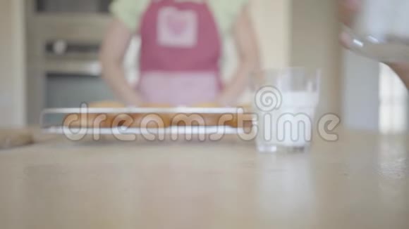 手突然把一个杯子和牛奶放在桌子上把它洒在桌子上特写穿着围裙面目全非的女人视频的预览图