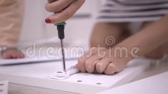 硬手收盒特写一个女人正在用螺丝刀组装一个白色的木柜视频的预览图