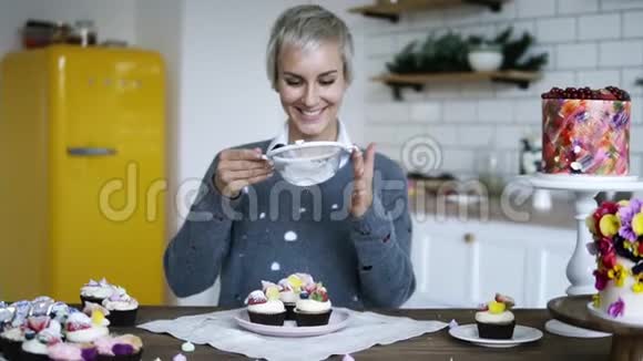 年轻女性糖果装饰美味花哨装饰的纸杯蛋糕带着灰色头发糖霜的女人视频的预览图