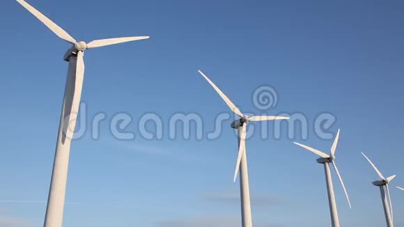 沙漠中的风力涡轮机在蓝天的映衬下旋转视频的预览图