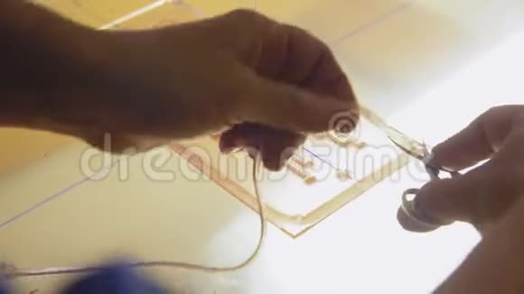 工人用剪刀在玻璃桌上剪下模板边缘视频的预览图