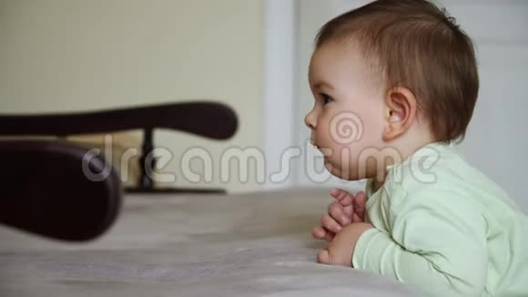 幼儿宝宝站在沙发附近看动画片在家里平静而集中平静的时间视频的预览图