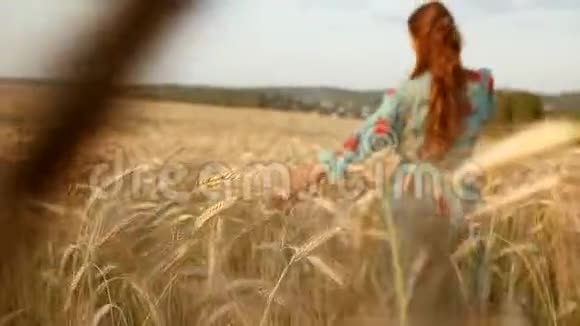 美丽的女孩穿着白色连衣裙奔跑着自然自由幸福双手在夕阳的光芒和蓝天的田野上女性视频的预览图