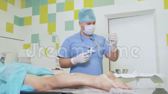 无菌衣的医生在手术前准备好医疗工具在病人腿部注射视频的预览图